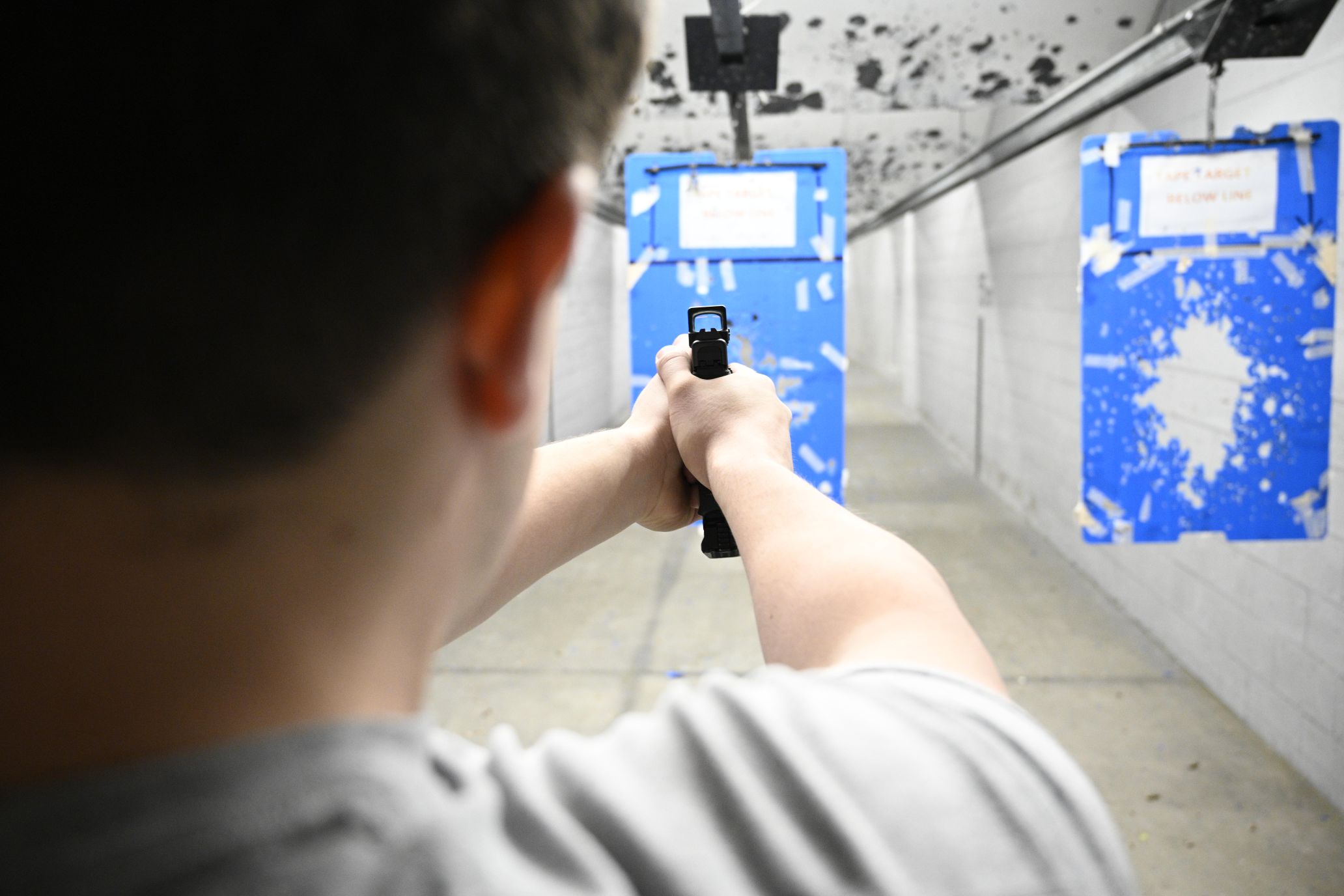 Photo over the shoulder, looking at gun sight aimed downrange